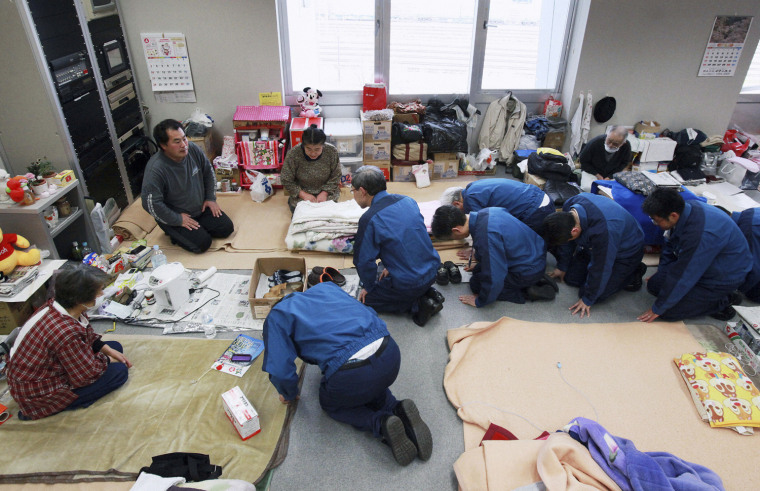 Image: TEPCO President Shimizu and company officials kneel as they bow to residents living in an evacuation centre in Koriyama
